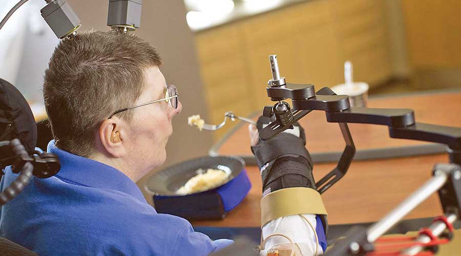 Paralysed man is able to feed himself for the first time in 30 years thanks to robotic arms